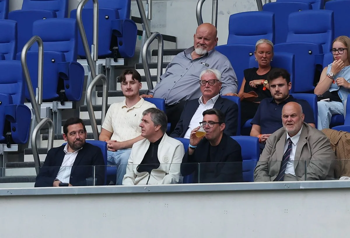 Andy Burnham enjoys a drink as he watched Leigh Leopards beat Warrington Wolves at Hill Dickinson Stadium